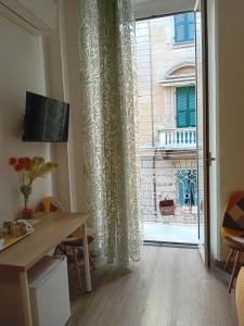 um quarto com uma mesa e uma grande janela em Titi Rooms em La Spezia