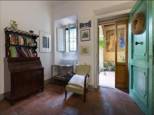 een woonkamer met een stoel en een boekenplank bij Borgo Ponte dell'Asse in Florence