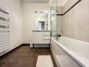 a bathroom with a tub and a sink and a mirror at "L'orchidée", confort et calme proche de Paris in Ermont