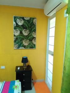 1 dormitorio con 1 cama y una pintura en la pared en Posada Hostel Adri, en Providencia