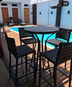 a table and chairs in front of a pool at Área de laser Gabata in Delfinópolis