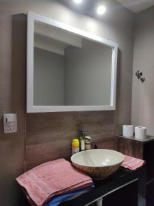 a bathroom with a sink and a large mirror at Apart Trelew 1 in Trelew