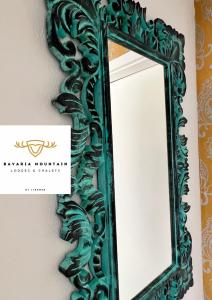 a green mirror with a carving on a wall at Bavaria Mountain Lodge SKI Arber Osser Bayrischer Wald DESIGNER Ferienwohnung in Lohberg