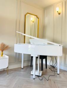 un piano blanco en una habitación con espejo en Gems in Ratoath, en Ratoath