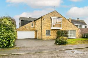 a brick house with a white garage at Spacious 3 Bed House with Large Garden in Aynho! in Aynho