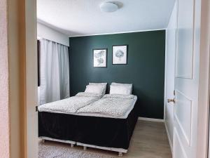ein Schlafzimmer mit einem Bett und einer grünen Wand in der Unterkunft Sapelin airbnb, Parkano in Parkano