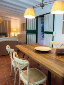 蒙特利亞諾的住宿－Ranchito de Alhucemas,piscina privada y barbacoa，一间带木桌和椅子的用餐室