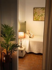 a bedroom with a bed with a lamp and a plant at Ranchito de Alhucemas,piscina privada y barbacoa in Montellano