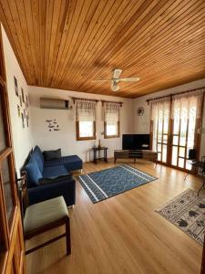 sala de estar con sofá azul y techo de madera en Stylish 3 room apartment with amazing sea views, en Dikili