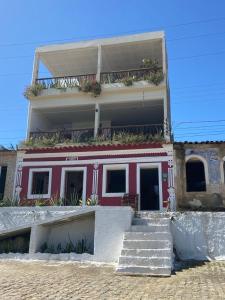 的住宿－Pousada Prazeres do Velho Chico，一座红色和白色的建筑,前面有楼梯