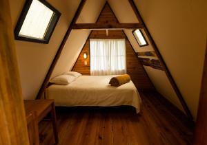 a bedroom with a bed and a window in a attic at Earth Lodge in Antigua Guatemala