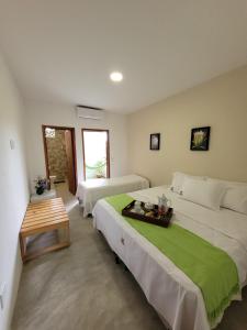 a bedroom with two beds and a table in it at Pousada Prazeres do Velho Chico 