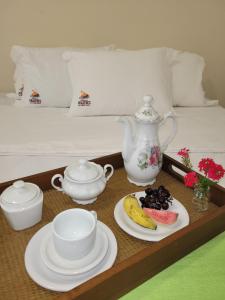 a tray with a tea pot and plates of food on a bed at Pousada Prazeres do Velho Chico 