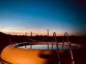a bath tub with a sunset in the background at La Bruyère - B & B - in Tréban