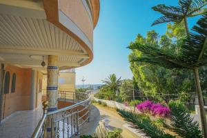 einen Balkon eines Hauses mit Bäumen und Blumen in der Unterkunft Villa vue sur mer avec piscine in Tangier