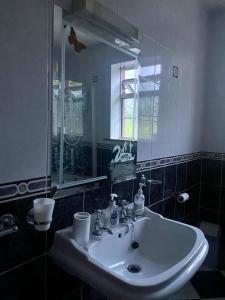 y baño con lavabo blanco y espejo. en Spacious Countryside 5BD House!, en Cavan