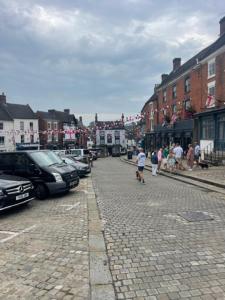 a group of people walking down a cobblestone street at Pet Friendly Cottage Ashbourne with Parking in Ashbourne