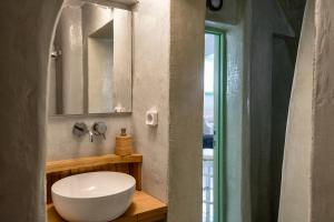 bagno con lavandino bianco e specchio di Mythos Traditional Stonehouse a Kamari