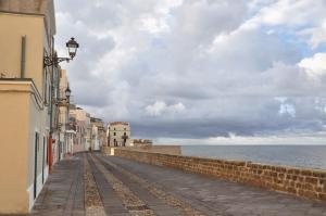 een lege straat naast de oceaan op een bewolkte dag bij camere Olmedo - 10 minuti da Alghero in Olmedo