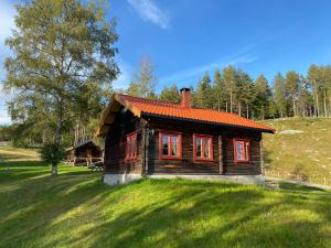una pequeña casa de madera en un campo de hierba en Bolkesjø Gaard en Notodden