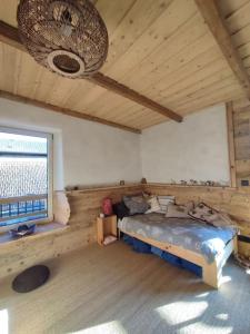 ein Schlafzimmer mit einem Bett in einem Zimmer mit einem Fenster in der Unterkunft T3 atypique en maison à 200m lac & piste cyclable in Saint-Jorioz