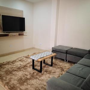 sala de estar con sofá y mesa de centro en Taroba Apart en Puerto Iguazú