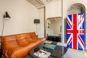 a living room with a couch and a glass table at Bail Mobilite Luxe Le Marais in Paris