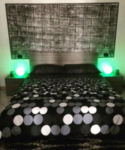 a bedroom with a black and white bed with green lights at Residenze Mquadro in Verona +7 photos
