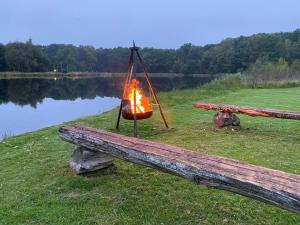 uma fogueira num cesto pendurado num banco ao lado de um lago em Skedala horsefarm em Halmstad