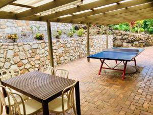 - Mesa de ping pong y sillas en el patio en Stunning Home in Mt Mellum with Panoramic Coastal Views, en Bald Knob