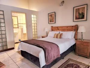 a bedroom with a large bed and a window at Villa Sardinia Guest House in Midrand