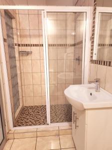 a bathroom with a shower and a sink at Villa Sardinia Guest House in Midrand