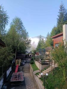 un jardin avec des tables et des bancs dans une cour dans l'établissement Садиба Бункер ЧАН, à Mijgiria