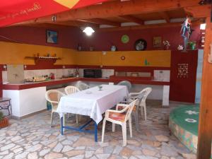 a dining room with a table and chairs in a kitchen at Vila Gjoka in Himare