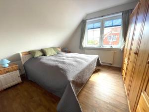 a bedroom with a bed and a window at Die Ostseeperle mit Pool 2 in Barendorf