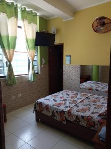 a bedroom with two beds and a flat screen tv at Luz de Luna in Piura
