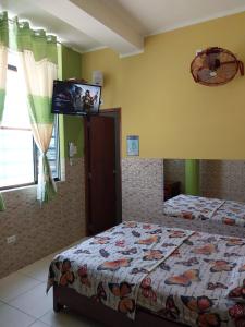 Schlafzimmer mit einem Bett und einem Flachbild-TV in der Unterkunft Luz de Luna in Piura