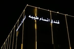 una señal en el lateral de un edificio por la noche en فندق انسام طيبة للضيافة, en Medina