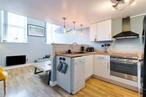 a kitchen with a sink and a stove top oven at Let's go sea in Swansea