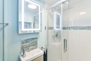 a white bathroom with a sink and a shower at Let's go sea in Swansea +9 photos