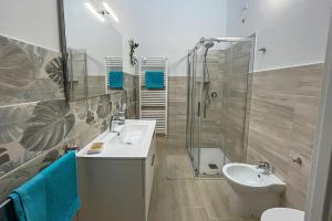 a bathroom with two sinks and a shower and a toilet at B&B Dimora Orrù in Càbras