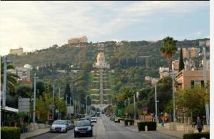 una strada cittadina con auto parcheggiate sul fianco di una collina di Apartment 4 Rooms נוה שאנן a Haifa