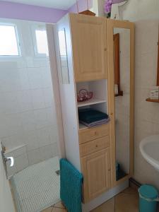 a small bathroom with a sink and a cabinet at Cottage le petit Tôt in Barneville-Carteret