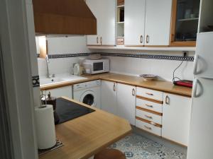 Casa en Purchil في غرناطة: مطبخ صغير مع دواليب بيضاء وميكرويف