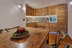 a kitchen with a wooden table and chairs at Du Soleil in Remondey