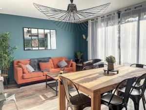 a living room with a couch and a table at Appart XXL -10 pers - 2 Pkg - 10 mn Paris in Épinay-sur-Seine