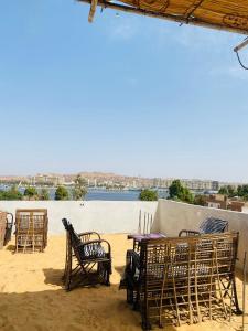 stół i krzesła z widokiem na wodę w obiekcie Nuba Heart w mieście Aswan