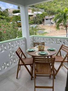 a table and chairs on a porch with a view at Studio Cocooning in Saint Martin