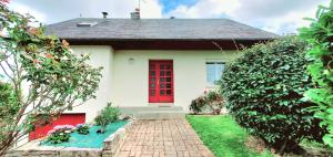 a white house with a red door and a brick driveway at Gîte de la valleuse, capacité 12 personnes, idéal pour une grande famille in Senneville-sur-Fécamp