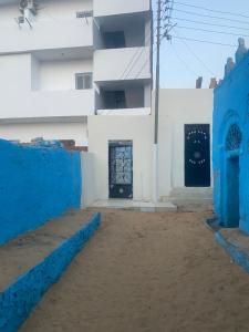 biały budynek z niebieskimi ścianami i drzwiami w obiekcie Nuba Heart w mieście Aswan
